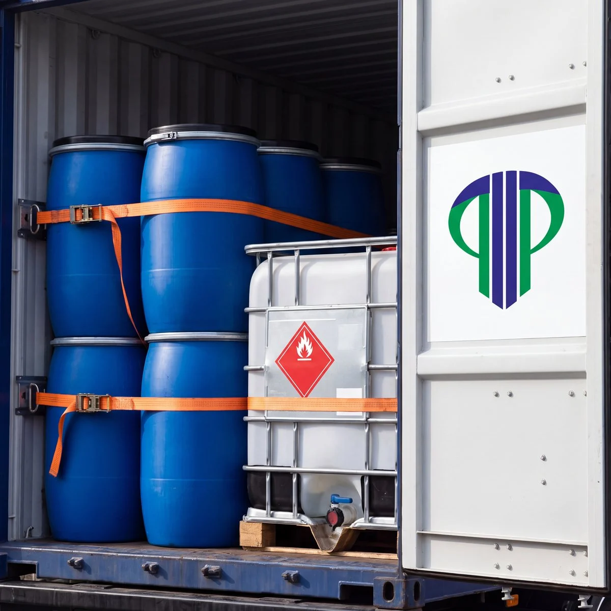 Sealed chemical drums and an IBC tote strapped inside a container, hazard placard visible