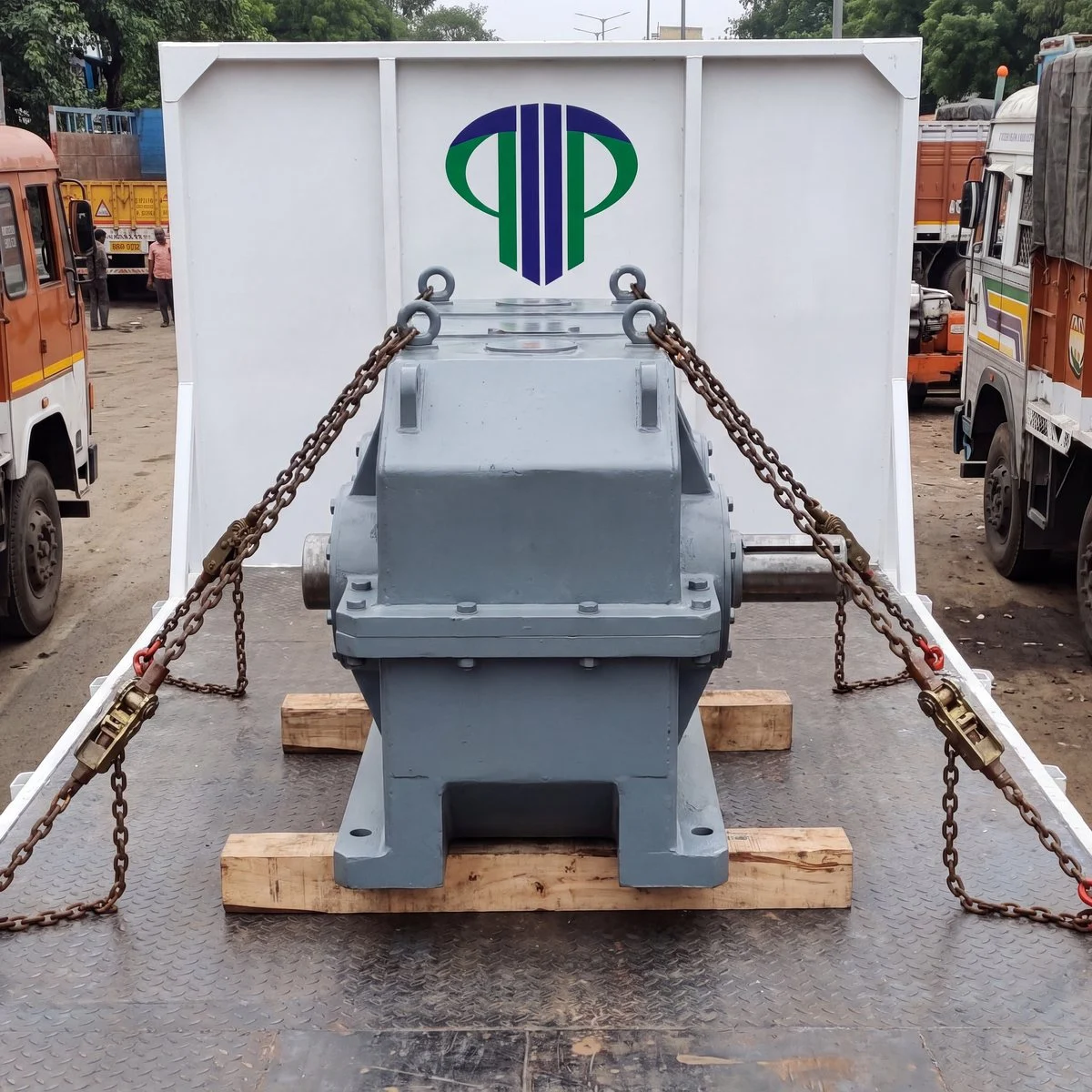 A heavy gearbox chained down on timber blocks on a flatbed trailer